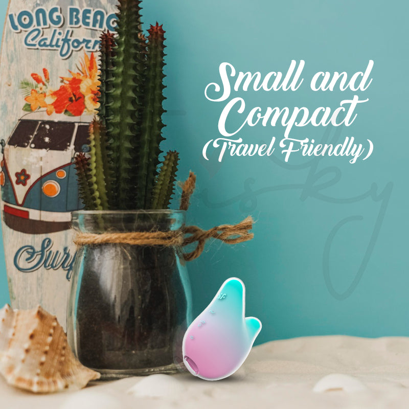 Small and compact Mermaid Vibes vibrator photographed beside books and indoor plant décor.