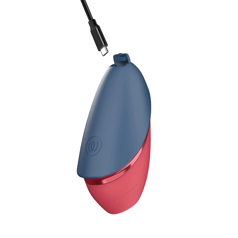 Womanizer Next Liberty connected to its magnetic USB charging cable for convenient recharging.