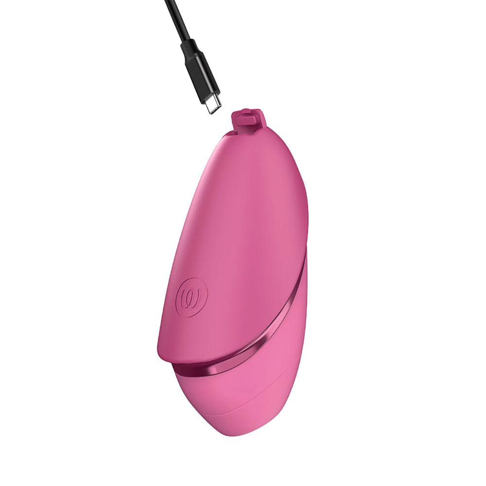 Womanizer Next Liberty connected to its magnetic USB charging cable for convenient recharging.