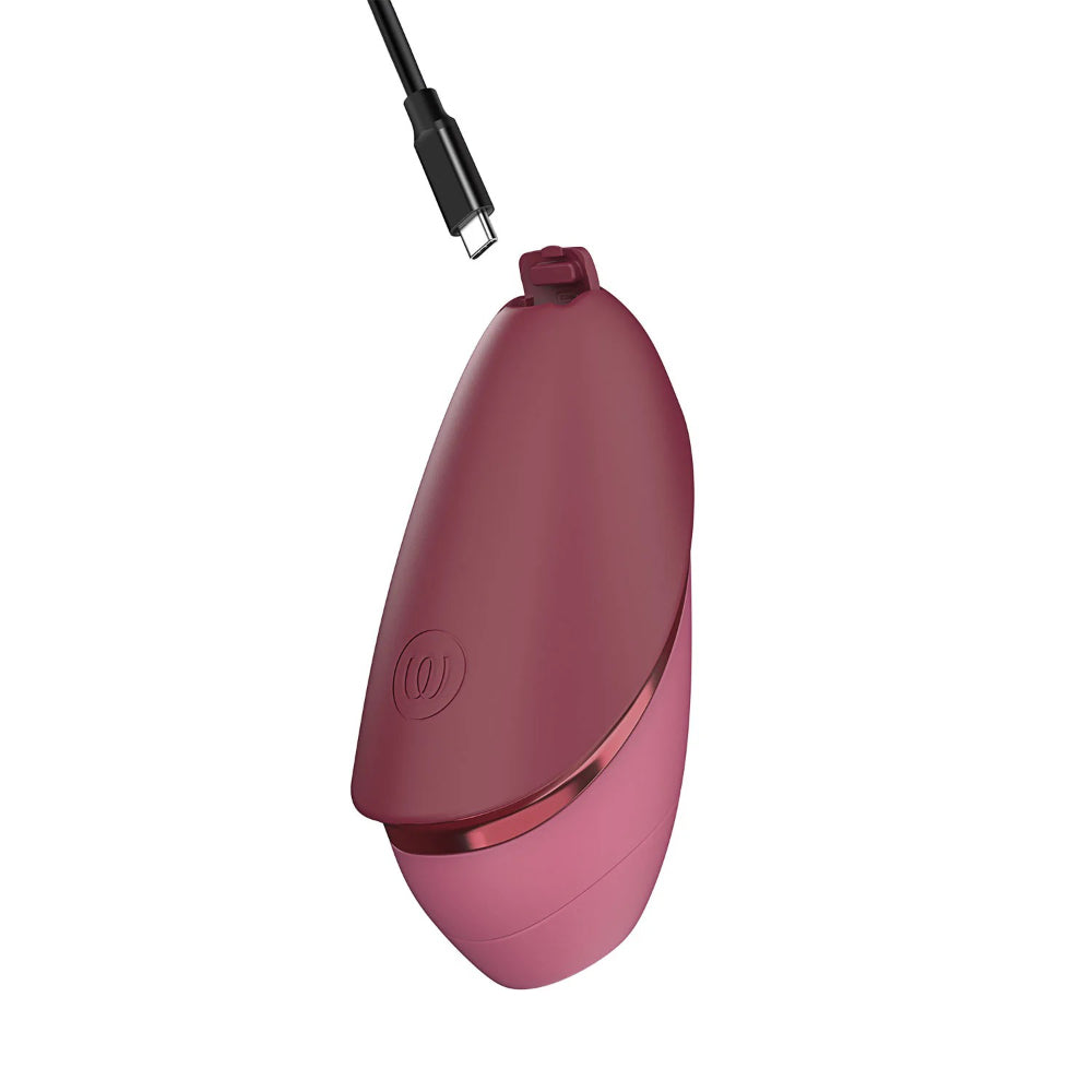 Womanizer Next Liberty connected to its magnetic USB charging cable for effortless recharging.